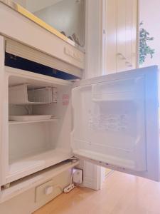 an empty refrigerator with its door open in a kitchen at Picolo Hakata in Fukuoka