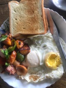 a plate of eggs and toast and a knife at Sunrise Point Homestay in Nagarkot