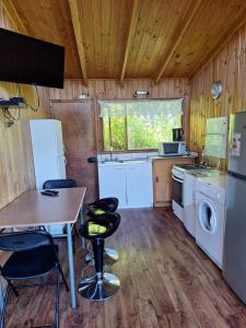 Una cocina con mesa y sillas en una cabaña. en Cabaña en Castro Chiloe, en Castro 19 fotos más