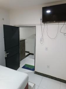 Habitación con cama y TV en la pared. en RESIDENCIAL ESPERANÇA en Teresina