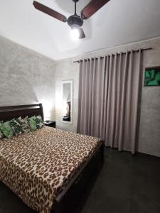 a bedroom with a bed and a ceiling fan at Flat Gorlaes in Araruama