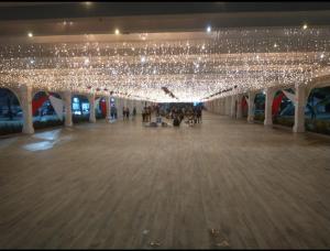 a large building with lights and a large empty hallway at O AP DO FÊ - Apartamento Praia Grande - Vila Tupi in Praia Grande