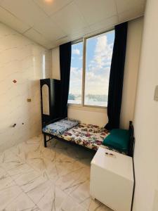 um pequeno quarto com uma cama e uma janela em Single room with window near metro no Dubai