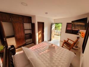 a bedroom with a bed with a table and a television at Hotel Randuky Tayrona in El Zaino