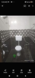 a bathroom with a white toilet in a tiled room at Shaurya Villa Guest House in Dānāpur