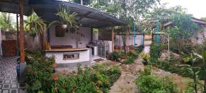 a garden with a kitchen and some flowers at AZALEA GARDEN HOMESTAY in Pagaralam