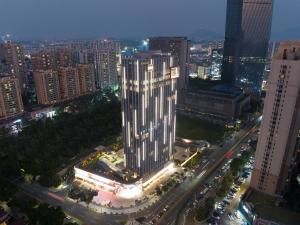 a view of a large building in a city at night at Sha Zhi Ye Serviced Apartment Hotel - Houjie Wanda Plaza Liaoxia Subway Station in Dongguan