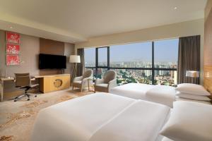 Cette chambre comprend deux lits et une grande fenêtre. dans l'établissement Renaissance Chengdu Hotel, à Chengdu