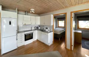 una cocina con electrodomésticos blancos y una habitación con cama en 2 Bedroom Lovely Home In Vaggeryd, en Vaggeryd