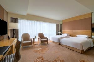 a hotel room with two beds and a flat screen tv at Renaissance Chengdu Hotel in Chengdu