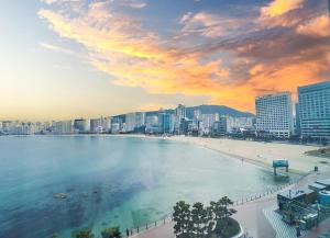 釜山的住宿－Ocean 2 Heaven Hotel，享有带海滩和建筑的城市美景