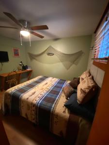 um quarto com uma cama e uma ventoinha de tecto em 4 Season Ranch 