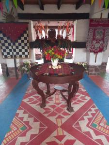 uma mesa com flores em cima de um tapete em Casona San Jorge em Lucre