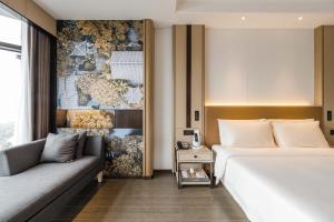 ein Hotelzimmer mit einem Bett und einer Couch in der Unterkunft Atour Hotel Tonglu Fuchunjiang in Tonglu + 70 Fotos