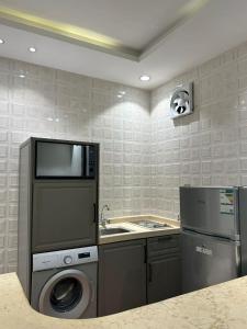 a kitchen with a washing machine and a sink at حكاية مسكن in Taif