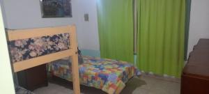 um pequeno quarto com uma cama e cortinas verdes em Departamentos Doña Viya em Ramallo