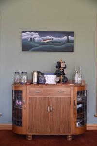 a wooden cabinet with glass doors in a room at 74 on Lockhart in Oturehua