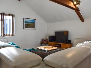 uma sala de estar com um sofá e uma televisão em Fairways Retreat em Northam