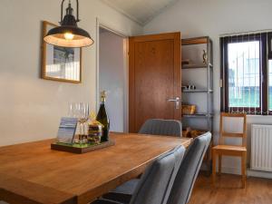 uma mesa de jantar com cadeiras e uma garrafa de vinho em Fairways Retreat em Northam