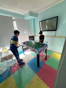 two boys playing a game on a table in a room at Pocitos Plaza Hotel in Montevideo