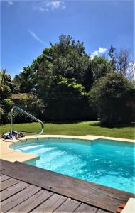 una piscina con terraza de madera junto a un patio en Chalet con piscina en San Luis, en San Luis