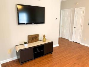 Una sala de estar con un televisor de pantalla plana en una pared. en *Come home - 1 mile from Duke & Downtown Durham, en Durham