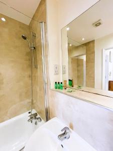 a bathroom with a sink and a shower and a mirror at Maidstone Heights By Kasar Stays in Kent