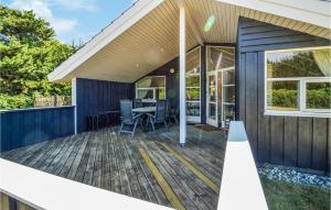 a deck with a table and chairs on a house at Three-Bedroom Holiday Home In Rodby in Rødby