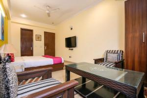 a hotel room with a bed and a table and chairs at Collection O Hotel Royal Suits in Gurgaon