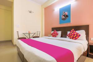 a bedroom with a large bed with pink and purple sheets at Collection O Hotel Royal Suits in Gurgaon