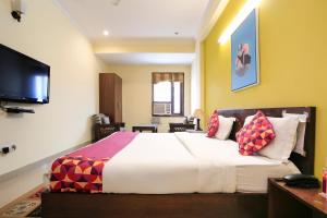 a bedroom with a large bed and a television at Collection O Hotel Royal Suits in Gurgaon