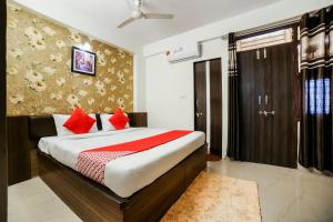 sypialnia z dużym łóżkiem z czerwonymi poduszkami w obiekcie Super OYO AARAV HOTEL w mieście Dżajpur