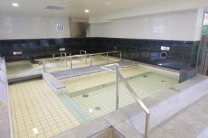 una gran piscina en un gimnasio en Sauna & Capsule Hotel Rumor Plaza en Kioto
