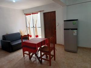 a living room with a table and chairs and a refrigerator at Doña Guada in Humahuaca