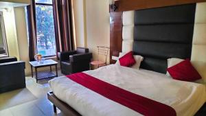 a bedroom with a large bed with red pillows at OYO Hotel Charlene in Mussoorie