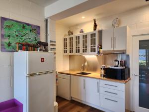 a kitchen with white cabinets and a refrigerator at Waterfront Abode - 2 bedrooms in Hobart