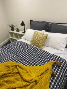 uma cama azul e branca com um cobertor amarelo em High Country Retreat em Jamieson