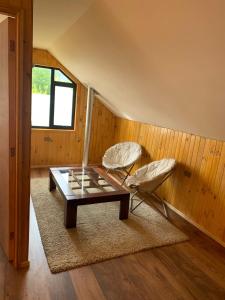 Habitación con mesa de centro y 2 sillas en Cabaña Coñaripe, en Coñaripe