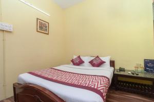 a hotel room with a bed with red and white pillows at OYO B Square Homes in Singānallūr