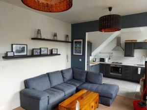 salon z niebieską kanapą i kuchnią w obiekcie Large 2 Bedroom City Centre Apartment + Parking w mieście Preston