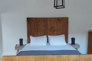 łóżko z drewnianą deską i białymi poduszkami w obiekcie Large 2 Bedroom City Centre Apartment + Parking w mieście Preston