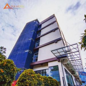 ein hohes Gebäude mit einem blauen in der Unterkunft AZKA HOTEL Managed by Salak Hospitality in Jakarta