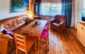 a living room with a table and a leather couch at 5 Bedroom Cozy Home In Rowy in Rowy