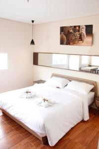 AZKA HOTEL Managed by Salak Hospitality في جاكرتا: سريرين في غرفة نوم مع ملاءات بيضاء