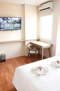 雅加達的住宿－AZKA HOTEL Managed by Salak Hospitality，客房设有1张床、1张桌子和1台电视。