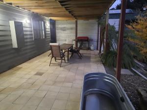 un patio al aire libre con sillas, mesa y mesa en Cock or Two Kink House, en Cockatoo
