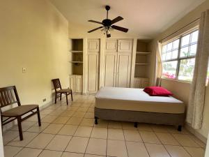 - une chambre avec un lit et un ventilateur de plafond dans l'établissement SAM TRAVEL, à Managua