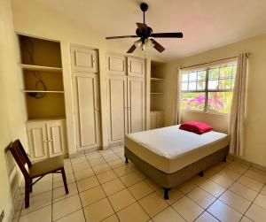 a bedroom with a bed and a fan and a chair at SAM TRAVEL in Managua