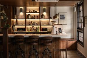 a bar in a restaurant with wooden cabinets and bar stools at Hanuman Boutique Stay &Eatery in Hat Yai