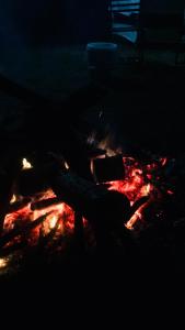a fire in the dark with a person sitting next to it at Vu Glamping in Hue